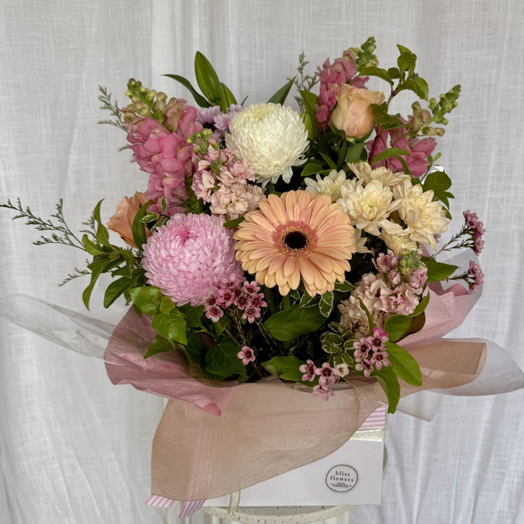 Boxed flower arrangement featuring fresh pink and cream blooms