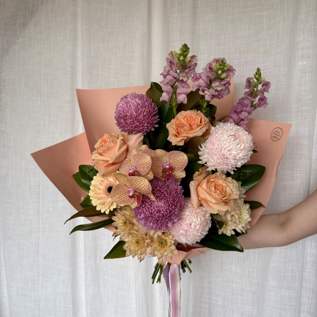 Fresh flower bouquets in soft pink and peach tones at She Bloomed florist
